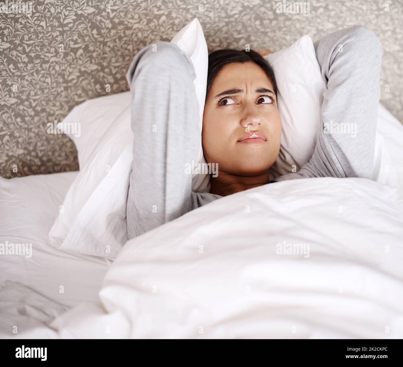 What is making that noise. A young woman looking frustrated in bed