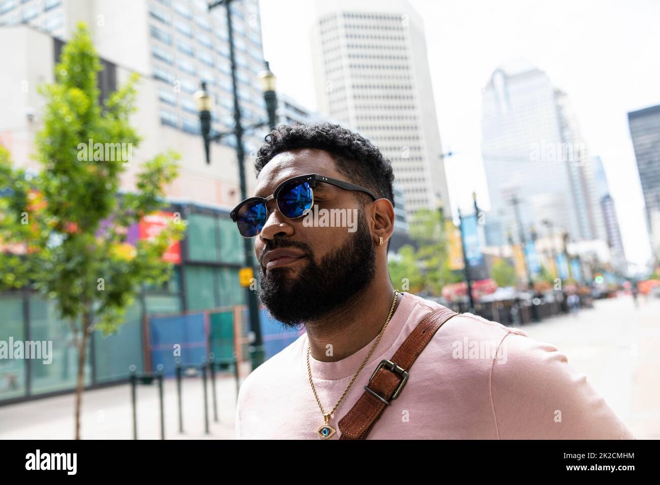 Portrait handsome man in sunglasses on city sidewalk Stock Photo
