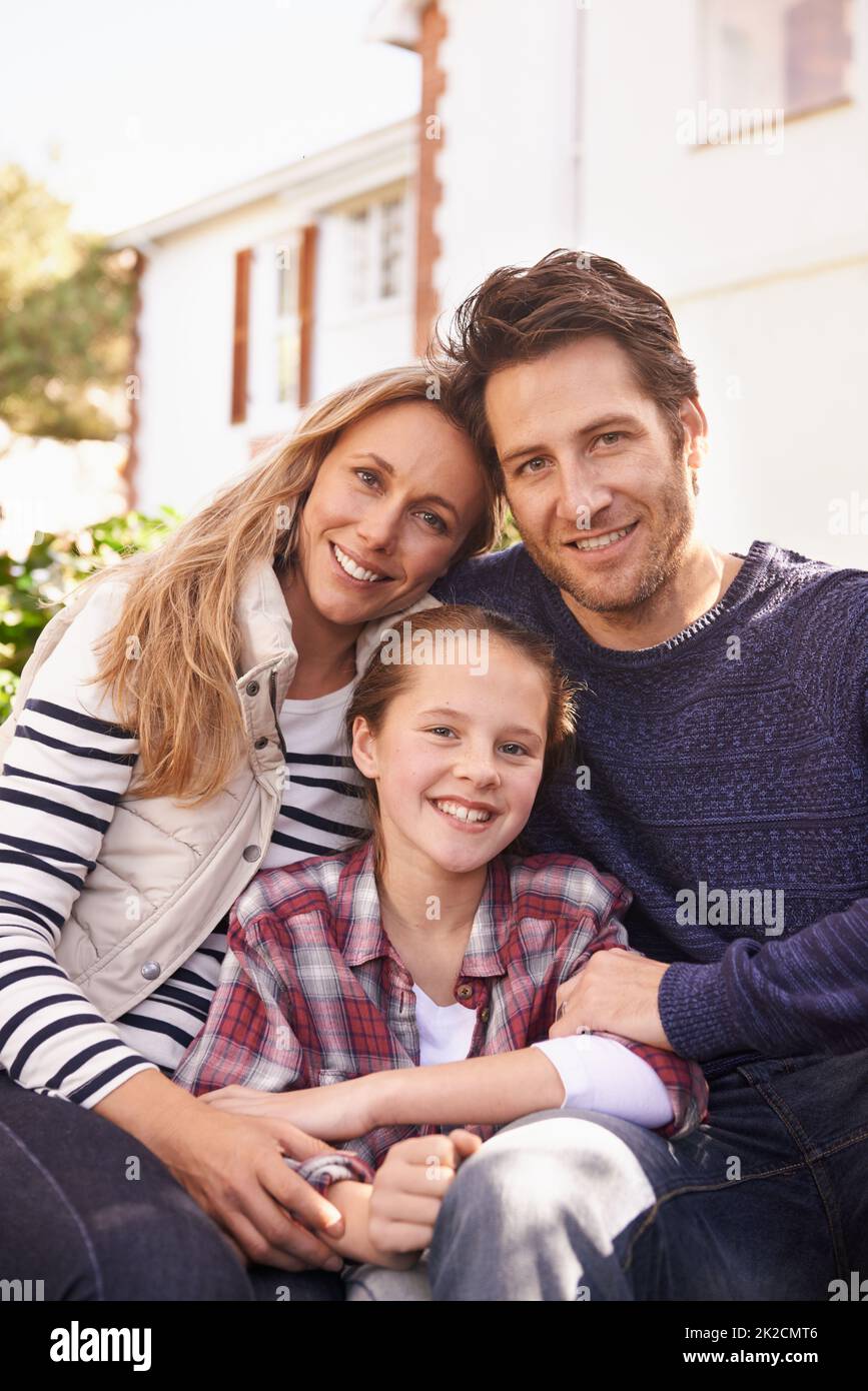 Happy at home. A portrait of a happy family posing outside their home. Stock Photo