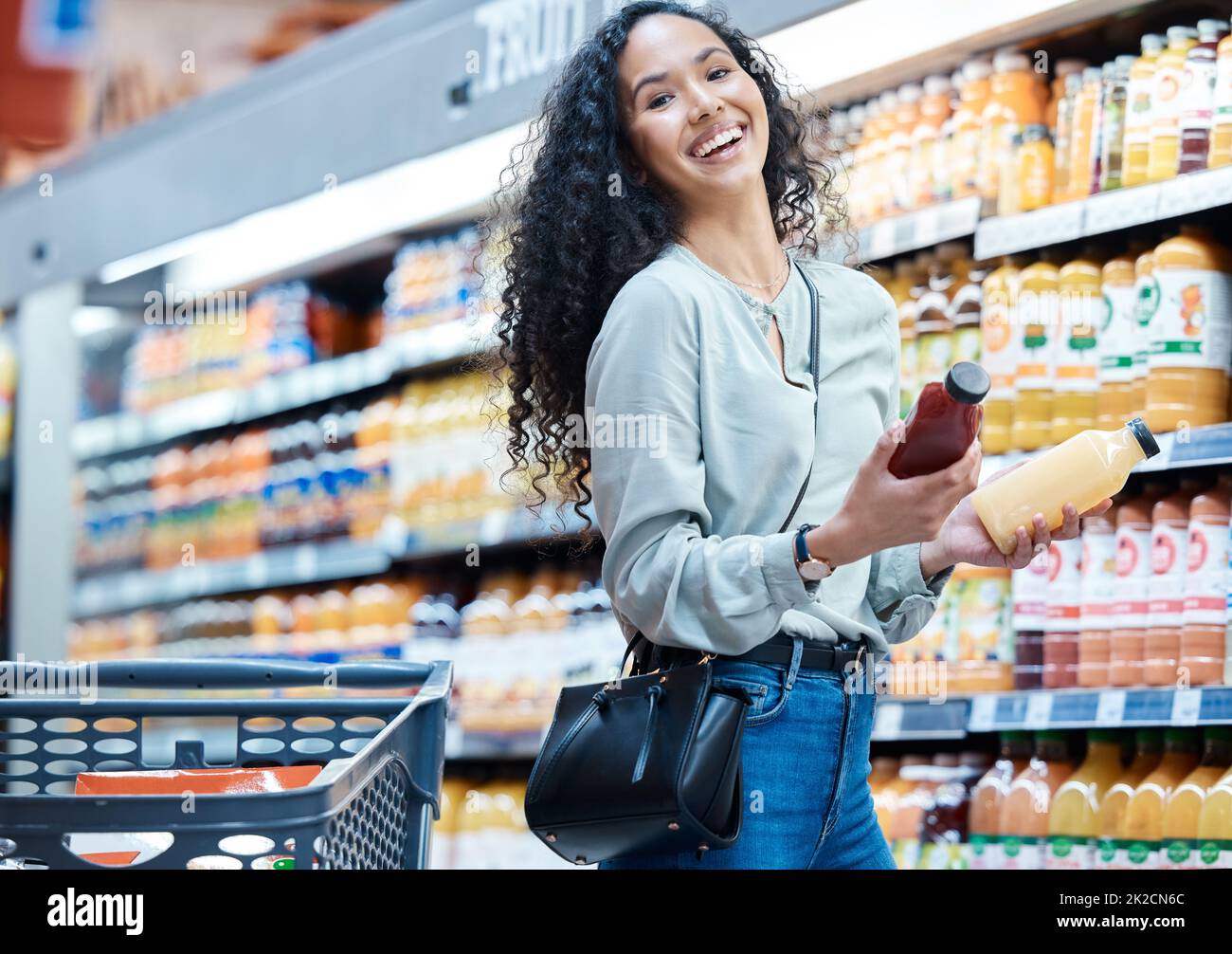 Woman with choice grocery shopping for juice in store, customer with healthy diet in supermarket and happy with retail sale on food at market Stock Photo