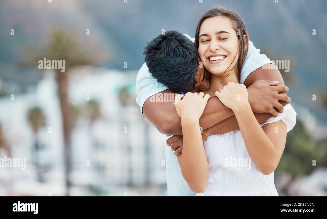 Love, hug and couple in happy relationship outdoor with city bokeh for holiday, vacation or weekend outing. Care, affection and carefree man embrace Stock Photo
