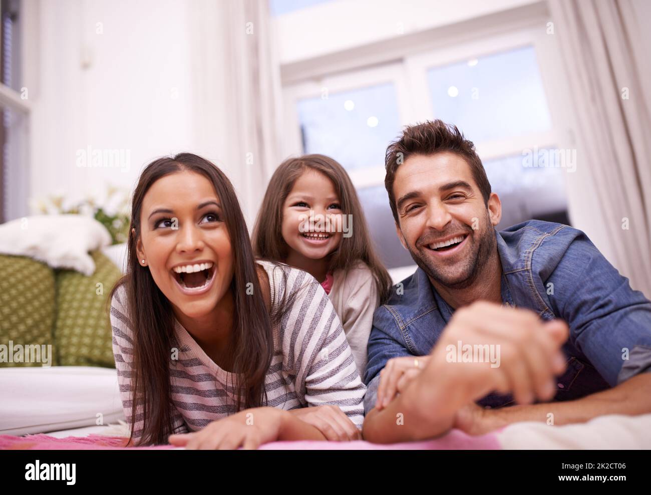 Love and laughter at home. Portrait of a happy young family at home. Stock Photo