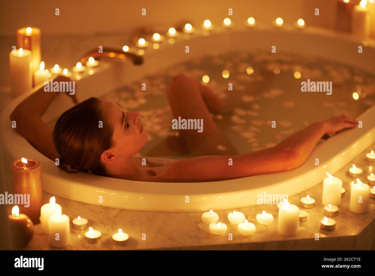 Relaxing Woman In Bath With Burning Candles Near by Stocksy Contributor  Sergey Narevskih - Stocksy