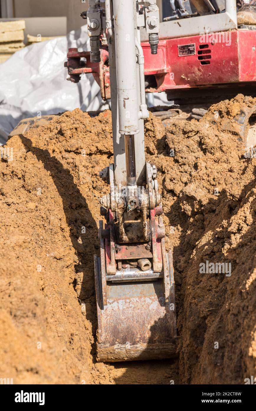 Small excavator as a construction machine on a construction site for earthworks Stock Photo