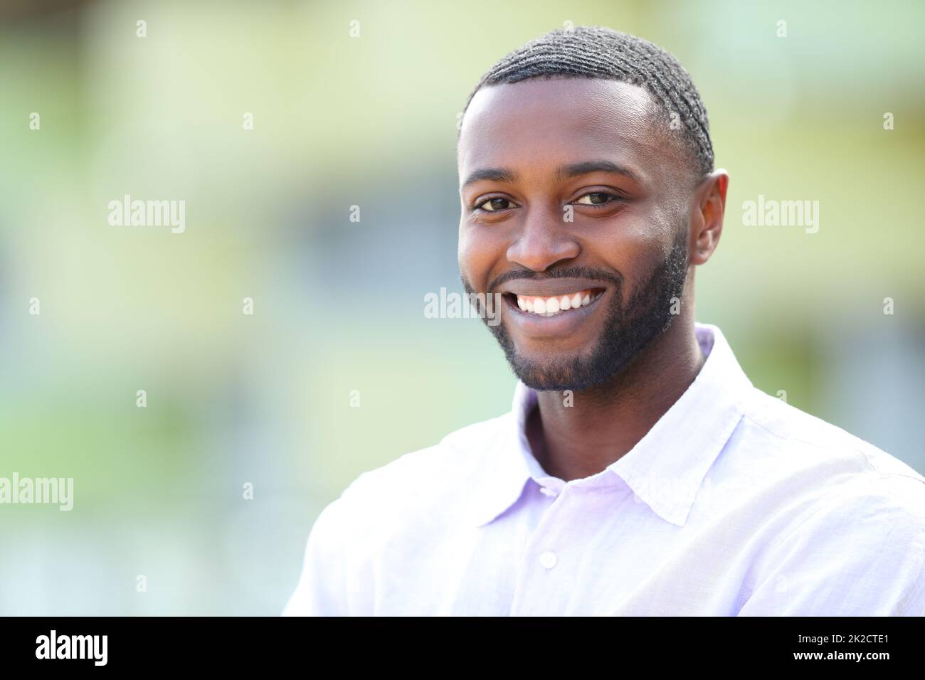 Handsome happy man with black skin looks at you Stock Photo