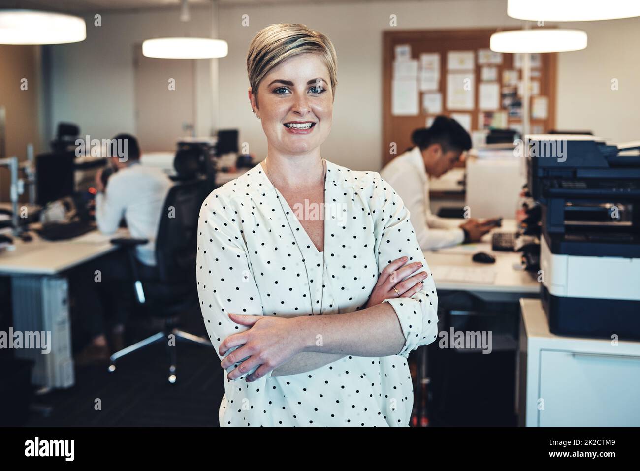 Shes here to implement structure in the office. Portrait of a businesswoman in the office while her colleagues are working in the background. Stock Photo
