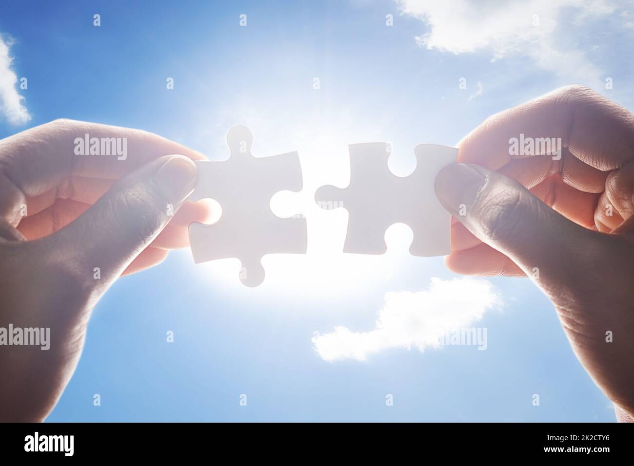 Together the make the perfect fit. Cropped shot of hands holding two puzzle pieces. Stock Photo
