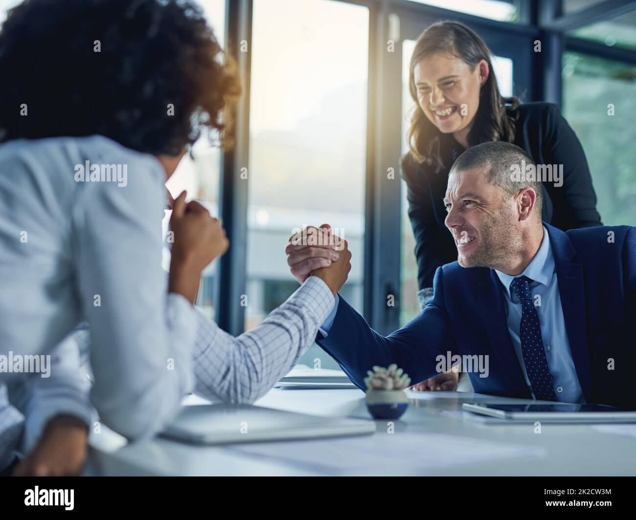 Theyre at loggerheads. Shot of two businesspeople arm wrestling during a meeting in the boardroom. Stock Photo