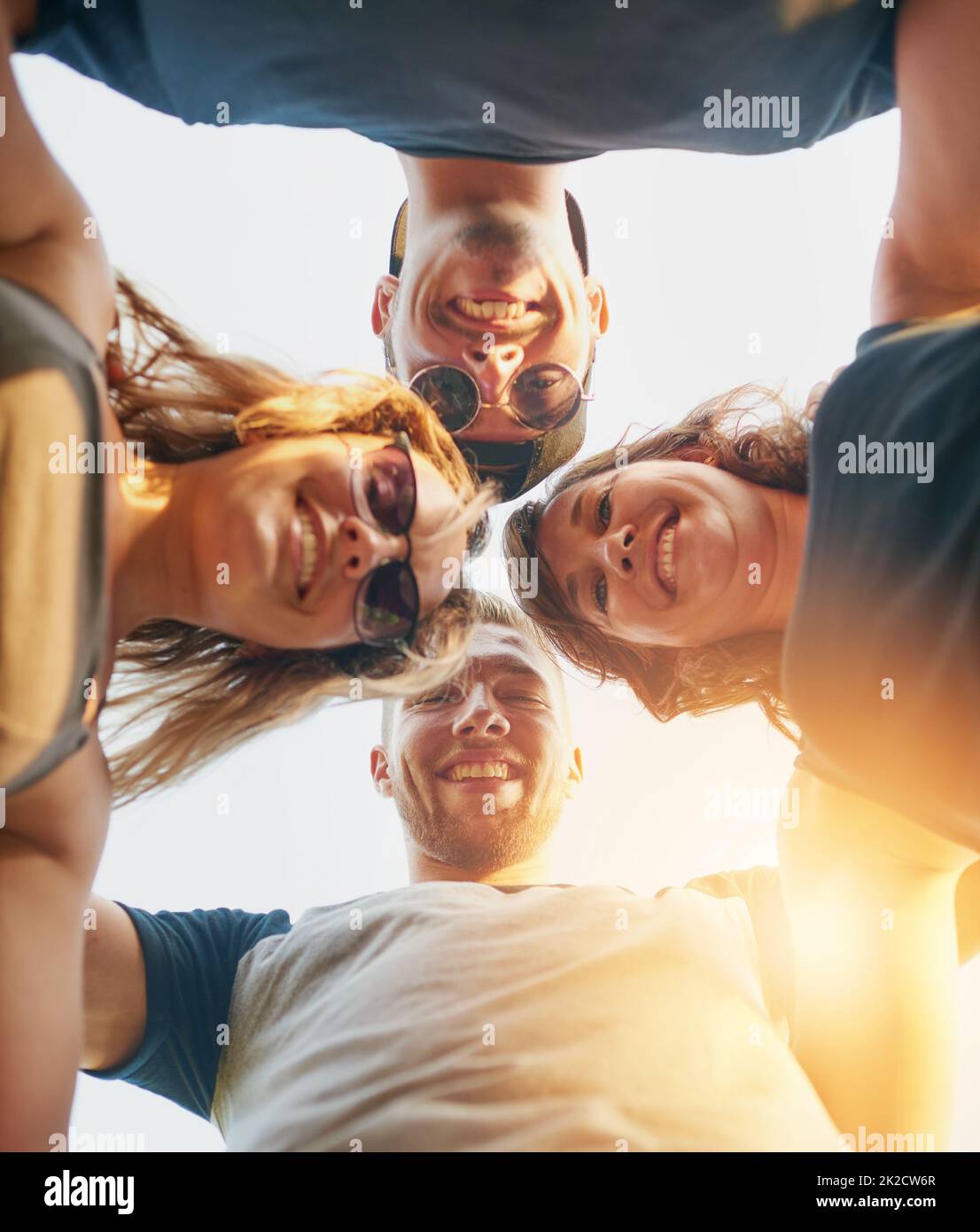 United in friendship. Low angle shot of a group of happy young friends posing outside. Stock Photo