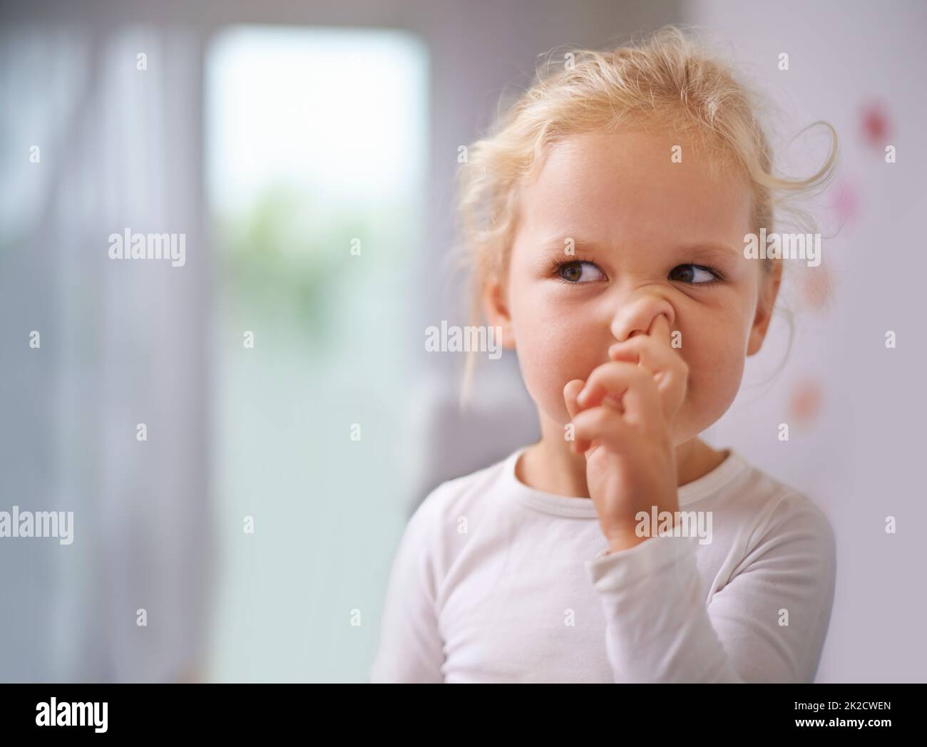 Digging for gold. A little girl picking her nose. Stock Photo