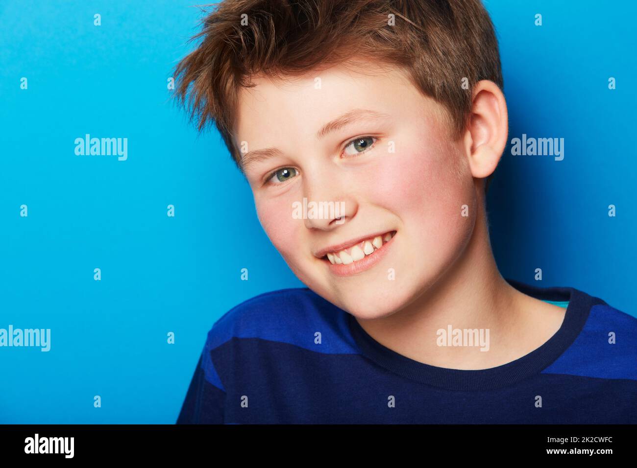 Giving you a toothy smile. Portrait of a young boy on a blue background