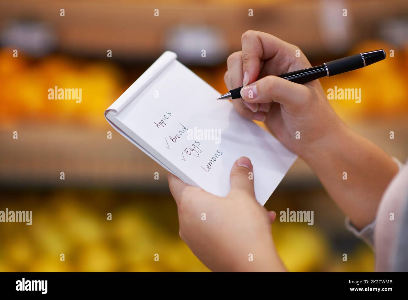 Ticking off her items as she goes along. Closeup shot of a woman