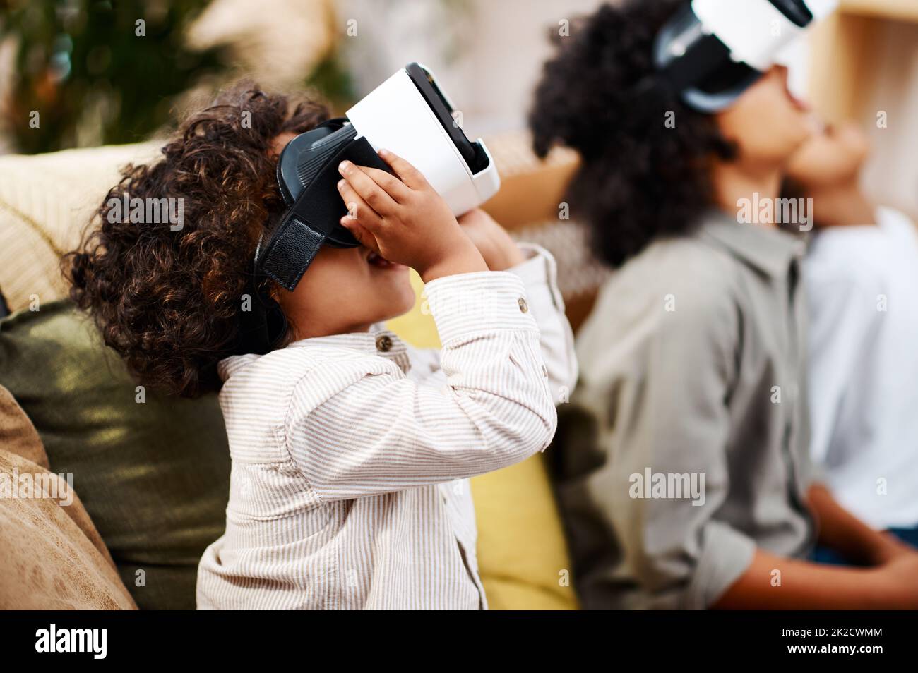 Theres a whole new world out there. Cropped shot of three little boys watching movies together through virtual reality headsets at home. Stock Photo