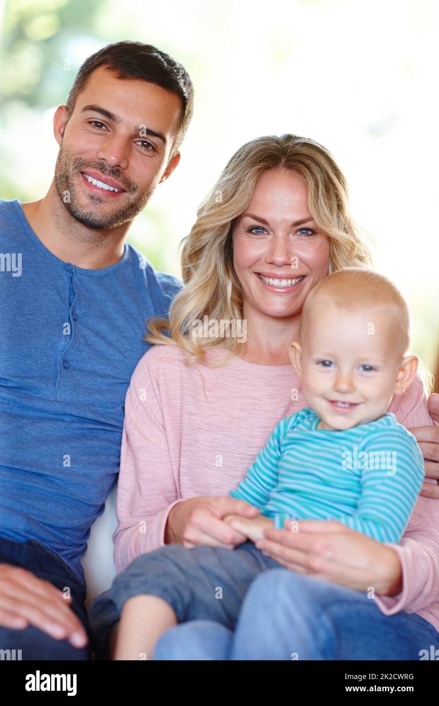 Hes our little bundle of joy. Portrait of a happy young family sitting at home. Stock Photo