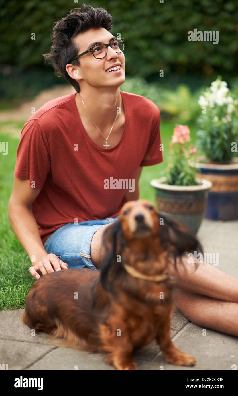 Mans best friend. Young guy hanging out with his dog outdoors. Stock Photo
