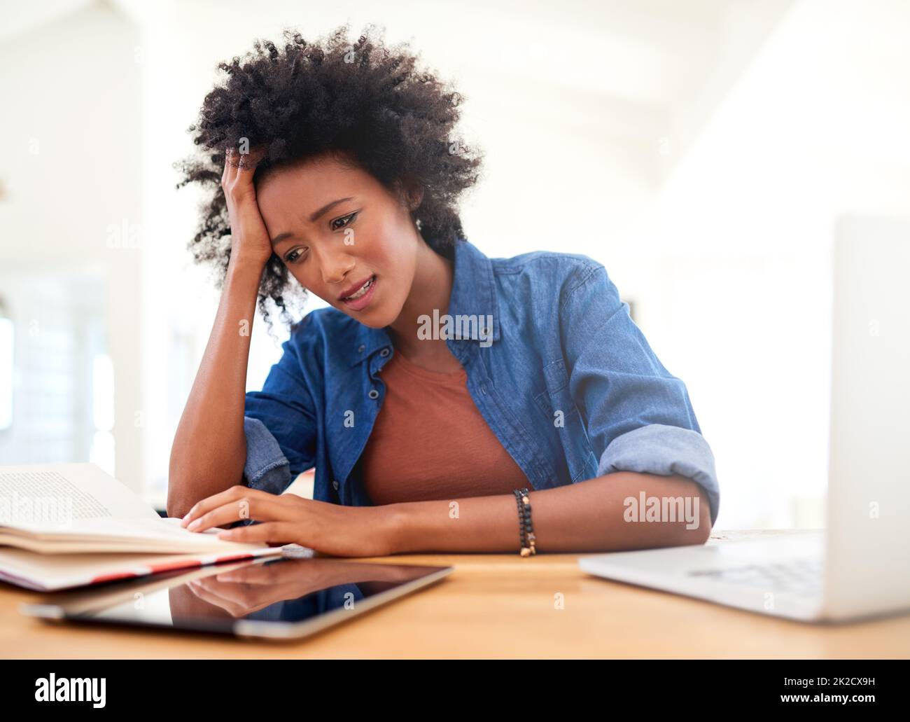 Work is stressing her out. Shot of an attractive young woman looking stressed while working from home. Stock Photo
