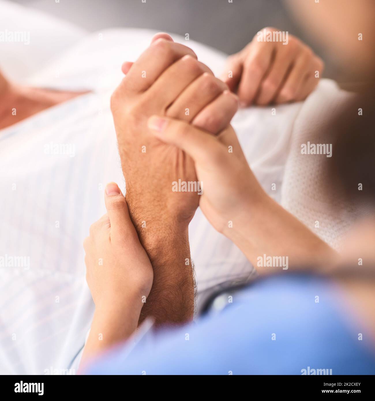 With you every step of the way. Closeup of a unrecognisable persons hand being held by a doctor inside a medical clinic. Stock Photo