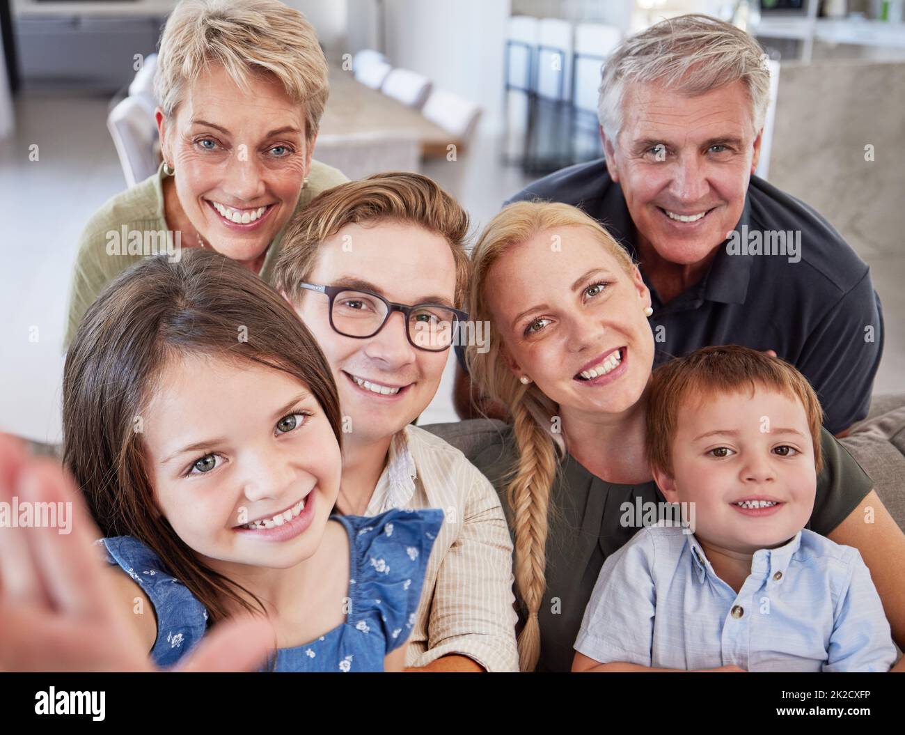 Family, children and selfie in bond with men, women and kids in house living room or home interior. Portrait, smile and happy mother, father and Stock Photo