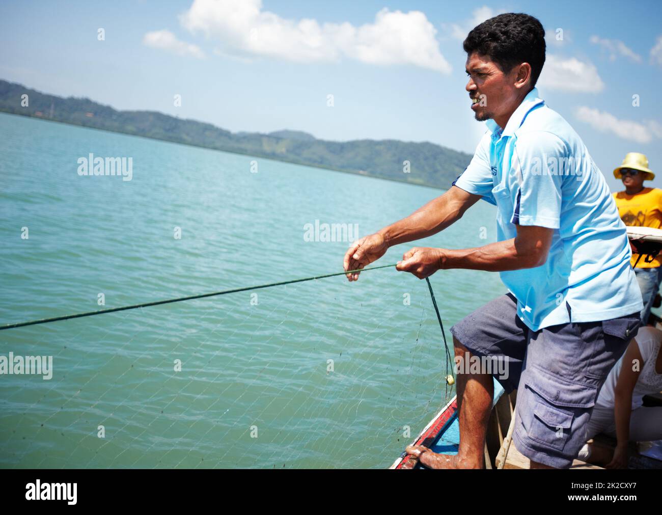 Great catch. Thai fisherman pulling in a haul on his fishing boat - copyspace. Stock Photo