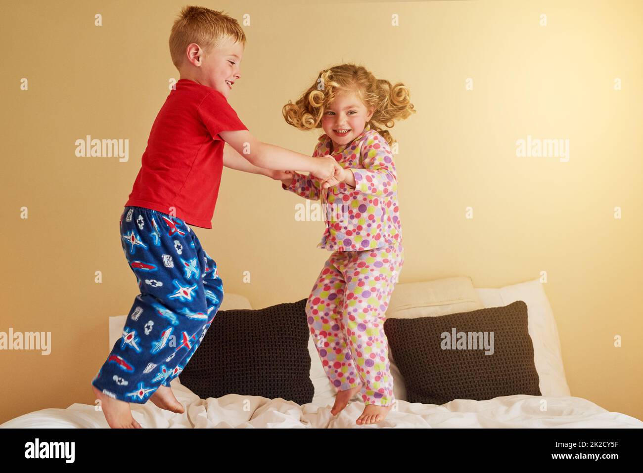 Kids know that beds were really made for jumping on. Shot of two little