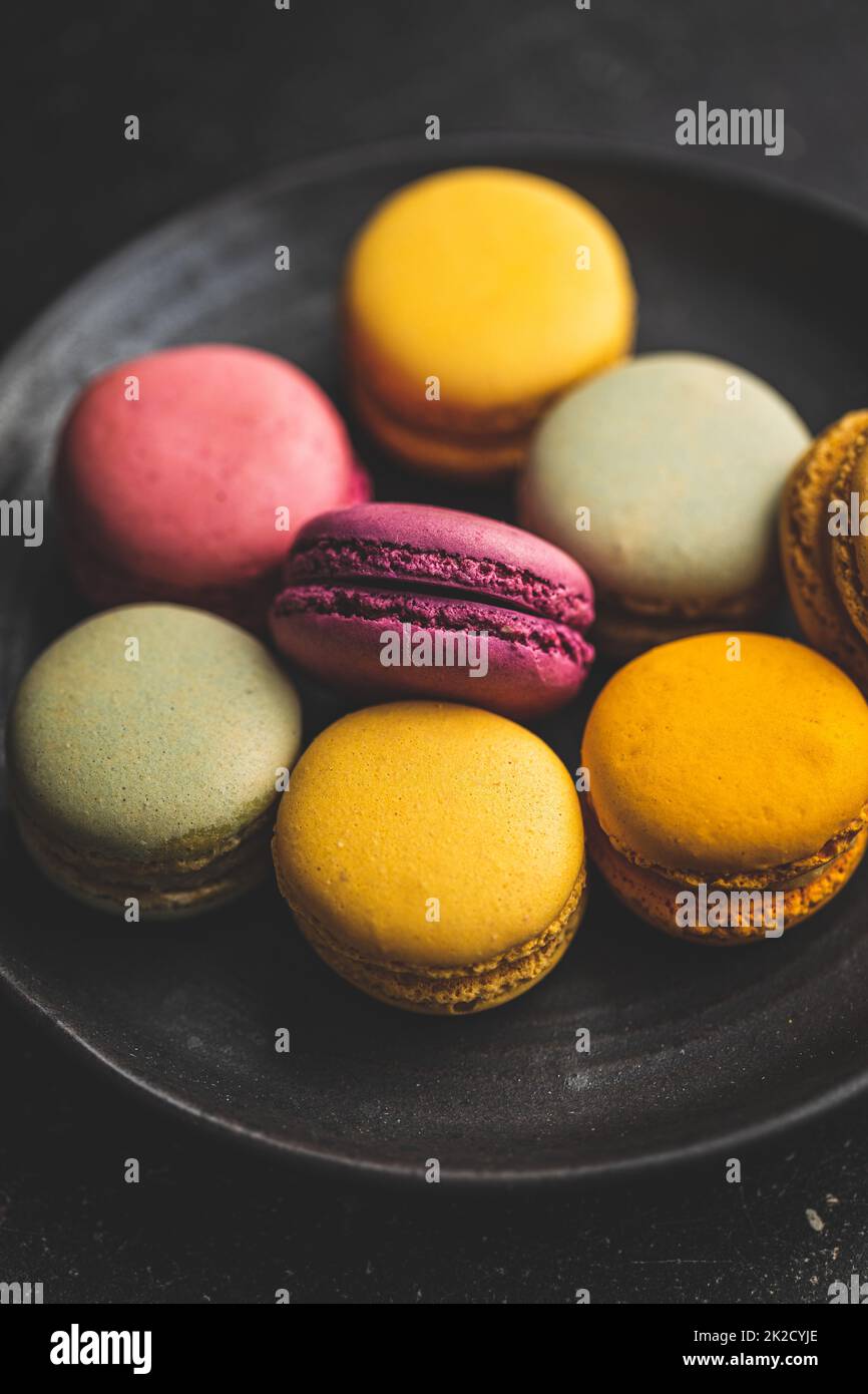 Sweet colorful macarons. Traditional french macaroons. Tasty dessert on plate. Stock Photo