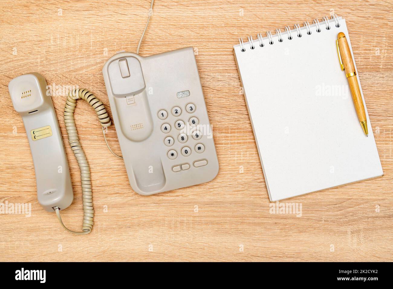 Vintage telephone and blank notebook on wooden background Stock Photo