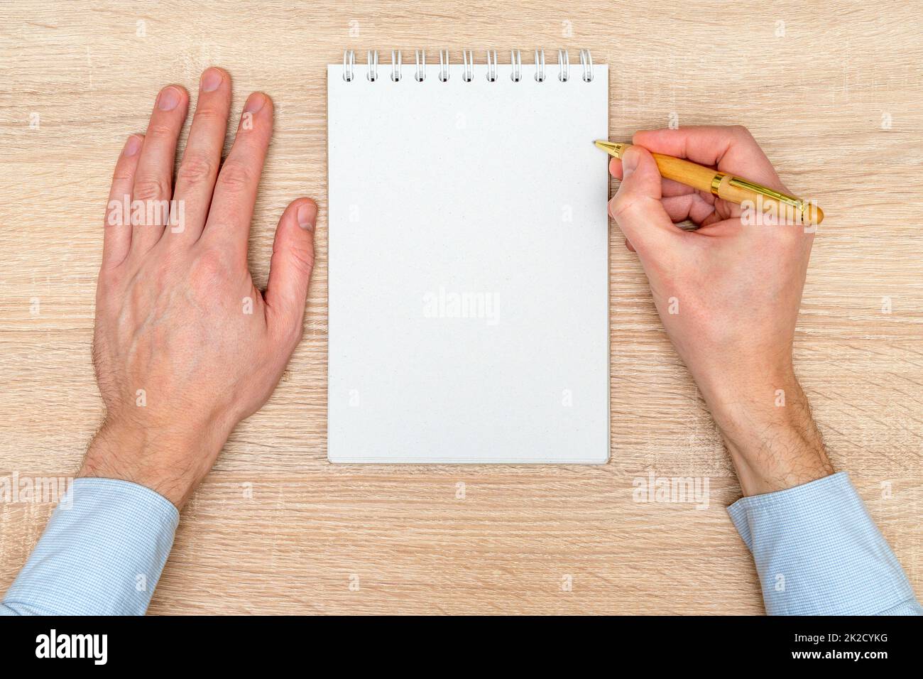 Hand writing in white blank open spiral notebook Stock Photo