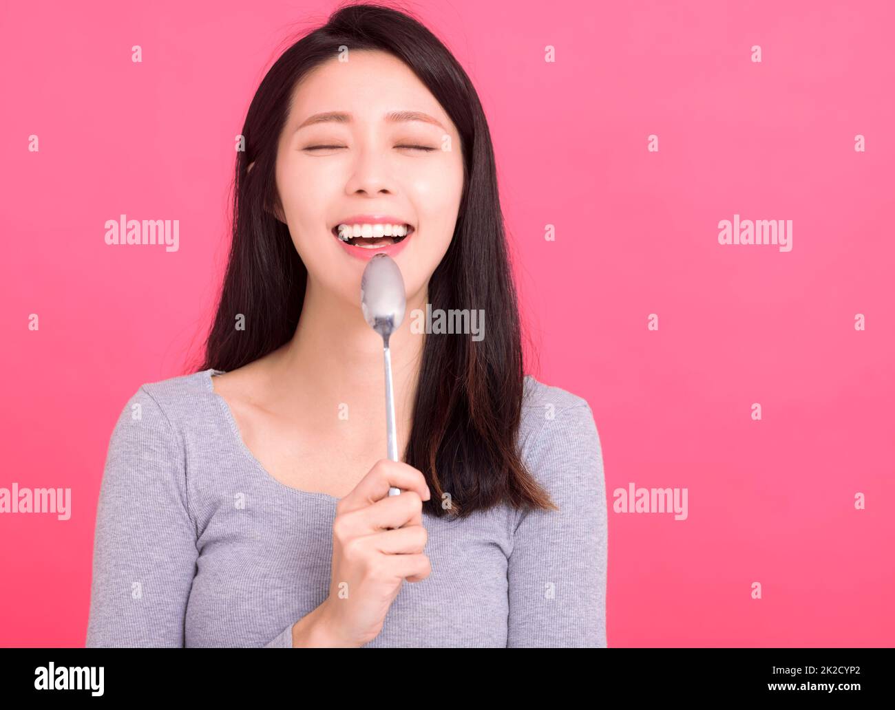 Happy and hungry lady hold metal spoon in mouth desire dinner think of tasty food Stock Photo