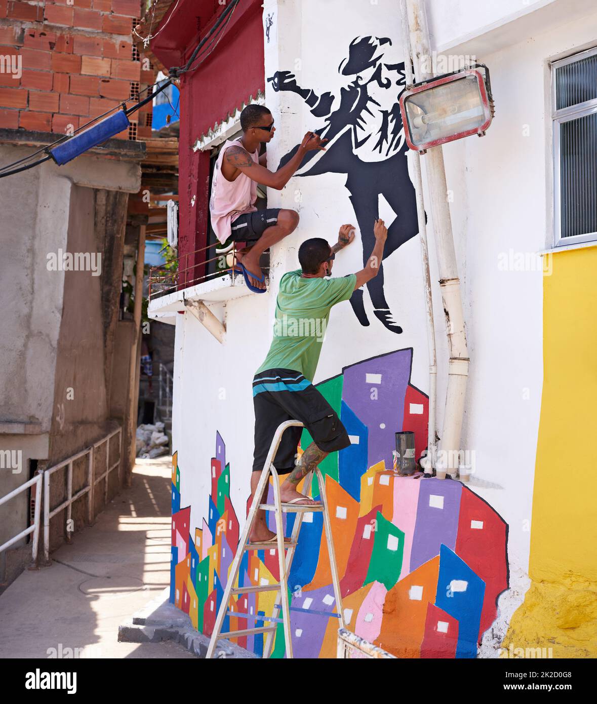 Shot of two young graffiti artists painting a design on a wall Stock
