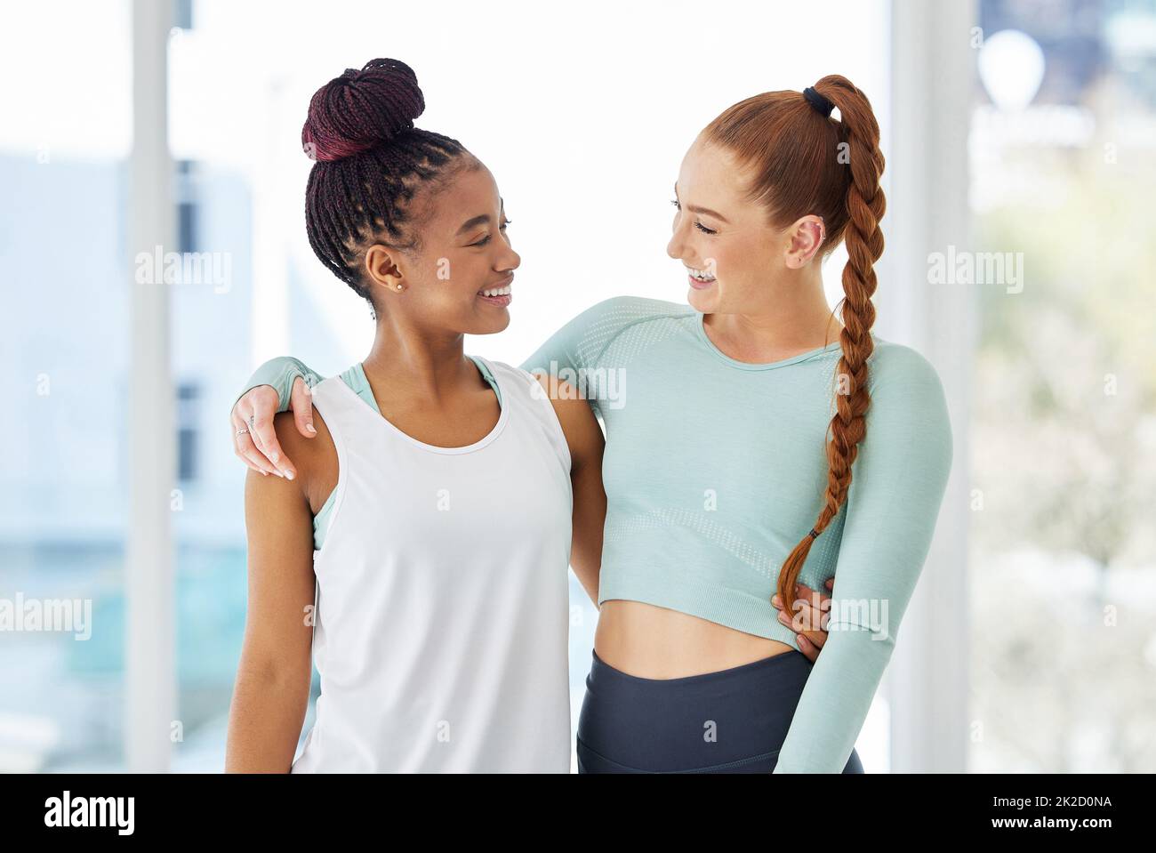 Friends who do yoga together stick together. Shot of two young women standing close together after practising yoga. Stock Photo