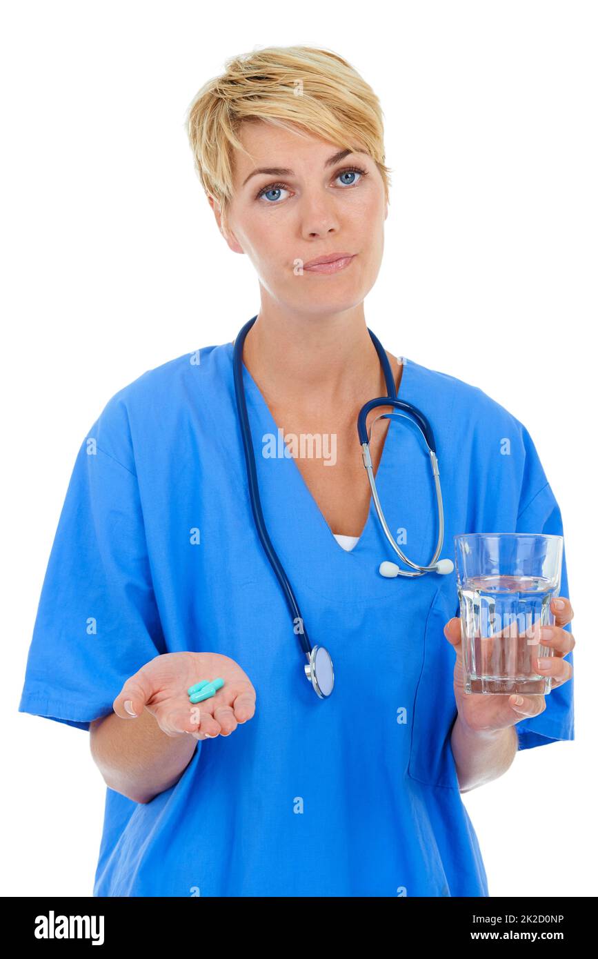 As prescribed by me. A young female doctor holding pills and a glass of water. Stock Photo