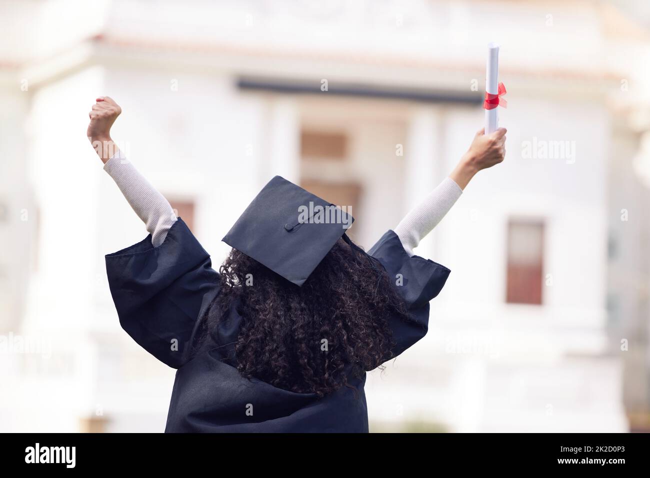 The best things happen when you believe you can. Rearview shot of a young woman cheering on graduation day. Stock Photo