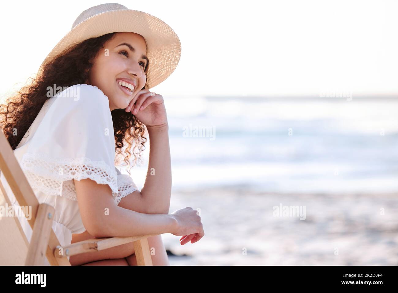 Im at my happy place. Shot of an unrecognizable woman enjoying a day at the beach. Stock Photo