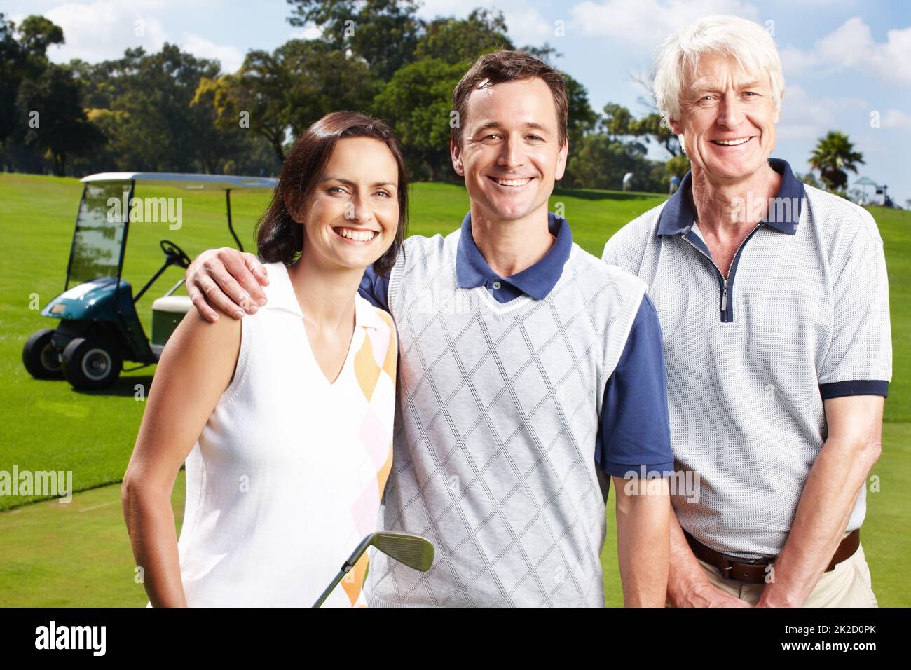 Bonding through a love of golf. Smiling golfing companions on the green with their golf cart in the background. Stock Photo