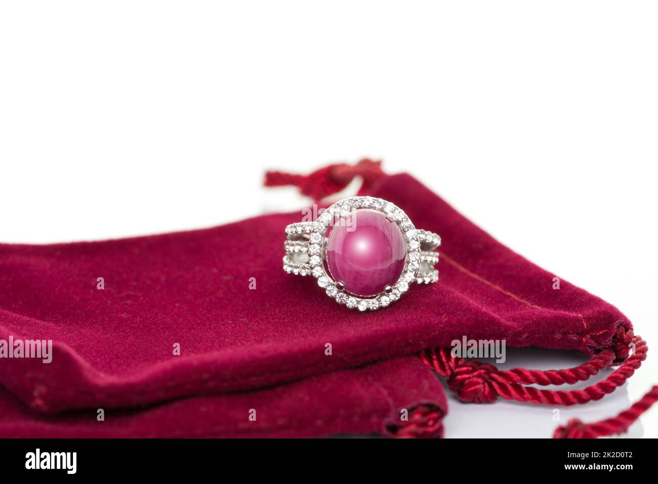 Ruby stone with diamonds ring on red velvet bag. Collection of natural gemstones accessories. Studio shot Stock Photo