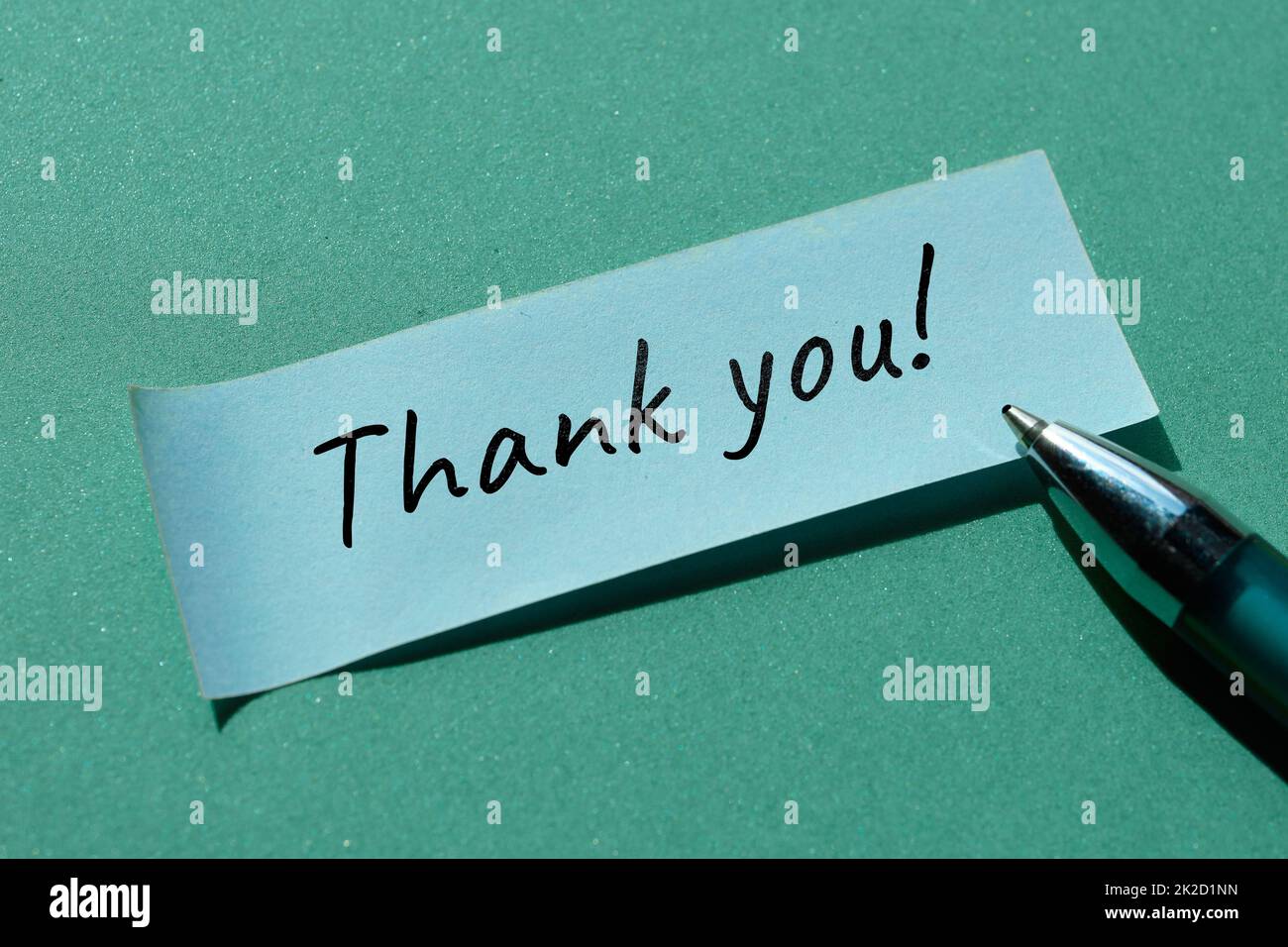 Message Thank you written on sticky paper, office sticker with pen. Simple minimal handwritten note on green background. Stock Photo