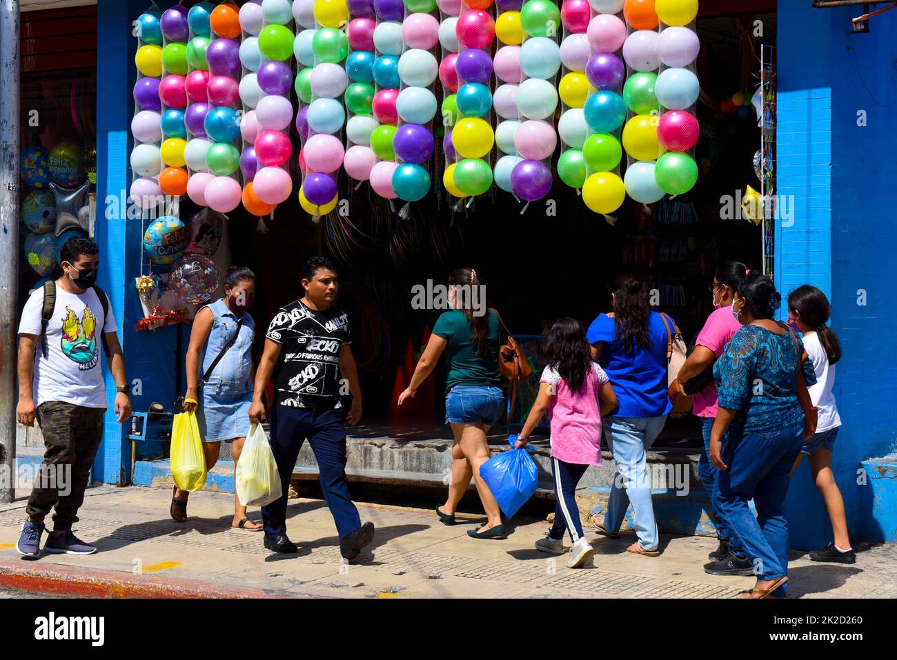 People walking in front of a shop selling balloons in downtown Merida, mexico Stock Photo