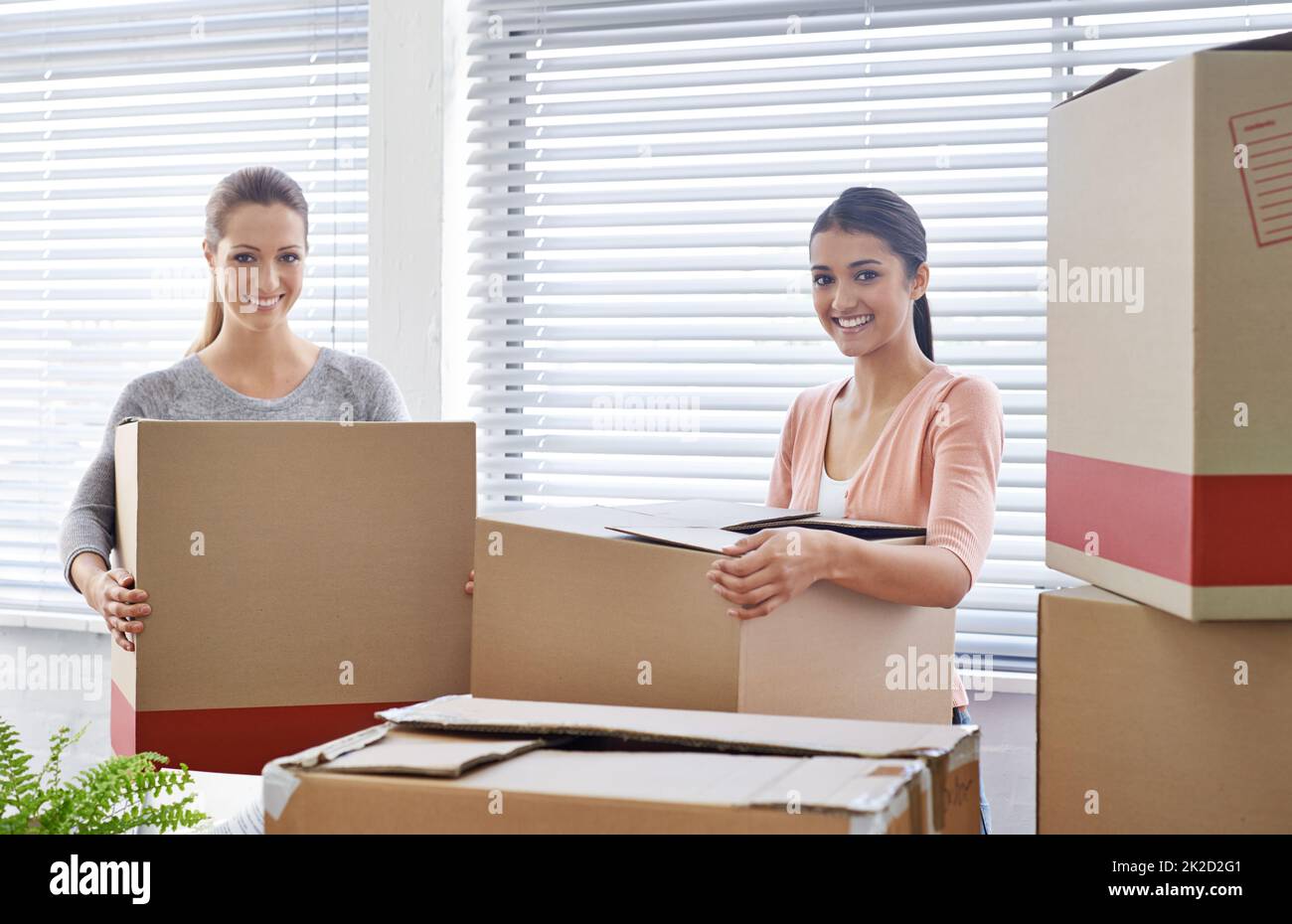 This new office is so spacious. Shot of two smiling businesswomen moving into a new office. Stock Photo