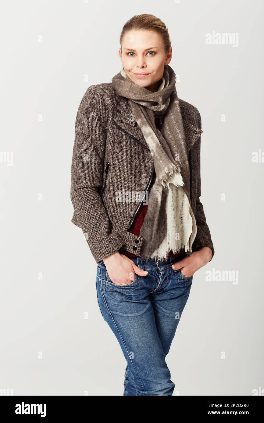 Cool and casual. Cropped studio portrait of a an attractive young woman standing with her hands in her pockets. Stock Photo