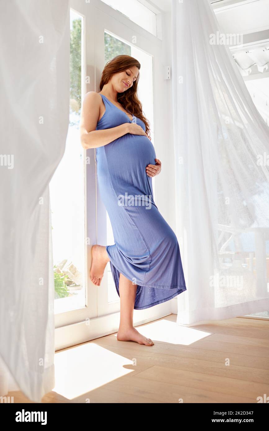 Made with true love. Expectant mother holding her pregnant belly with a smile. Stock Photo
