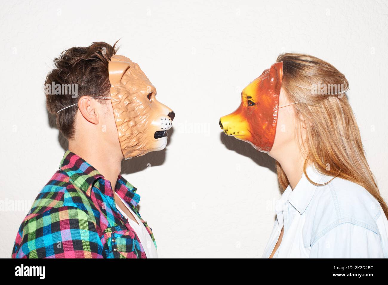 Facing off with animalistic intent. Shot of two young people face to face wearing animal masks. Stock Photo