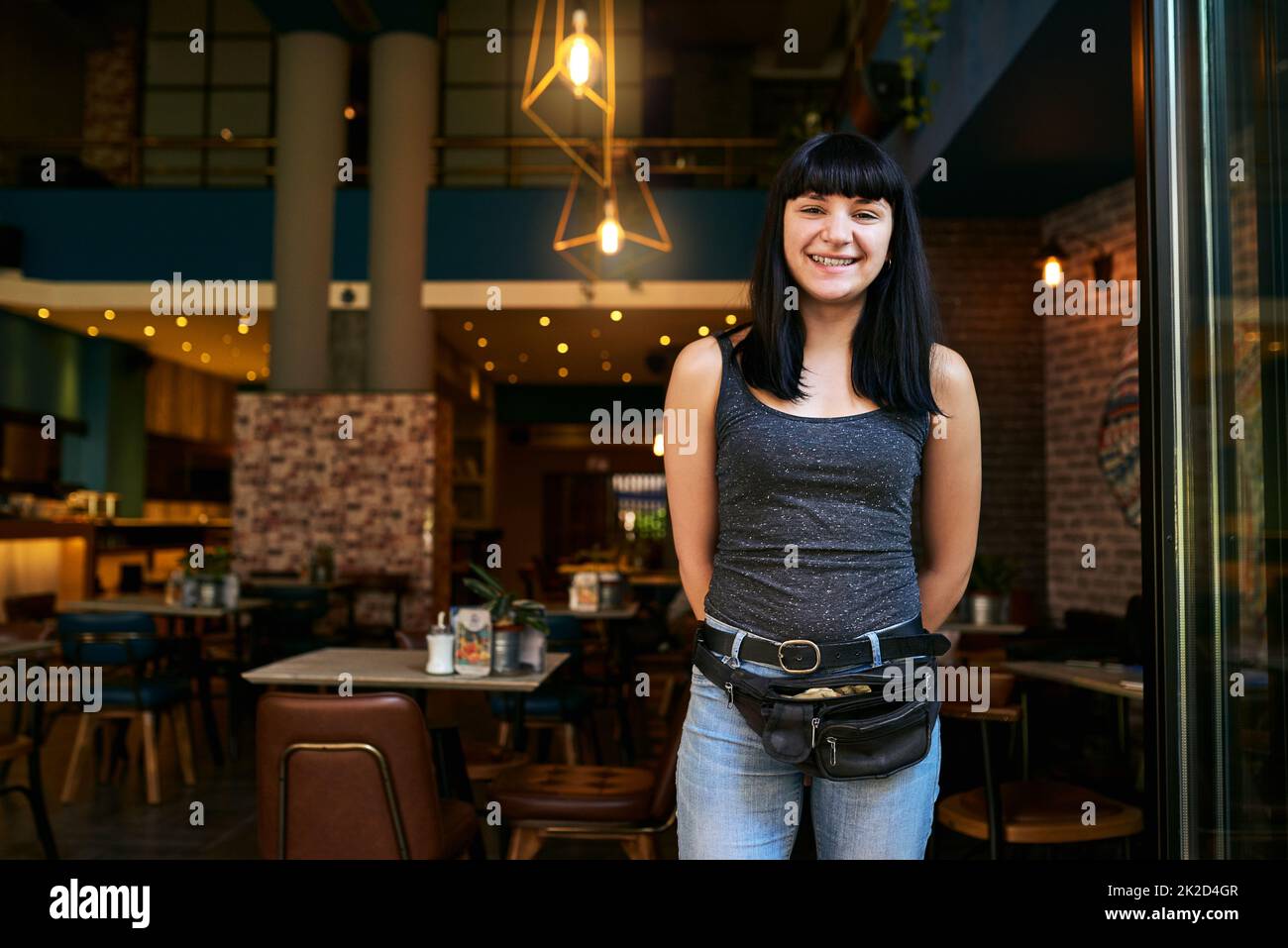 all customers for a delicious drink. Shot of a waitress working at a bar Stock Photo