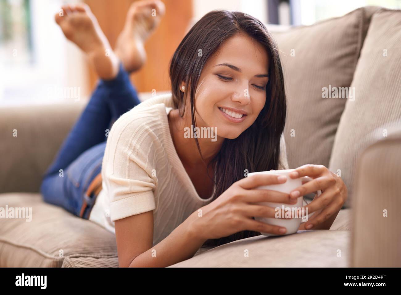 Nowhere more relaxing than home.... Shot of a beautiful young woman lying on the sofa at home. Stock Photo