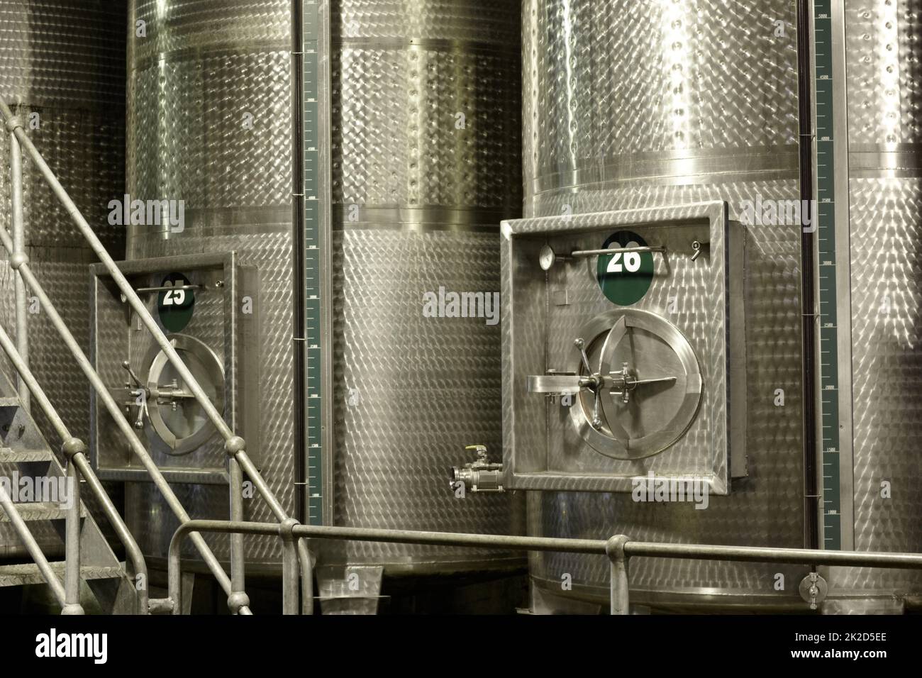 Fermentation in progress. Tankers for fermenting wine inside a wine factory. Stock Photo