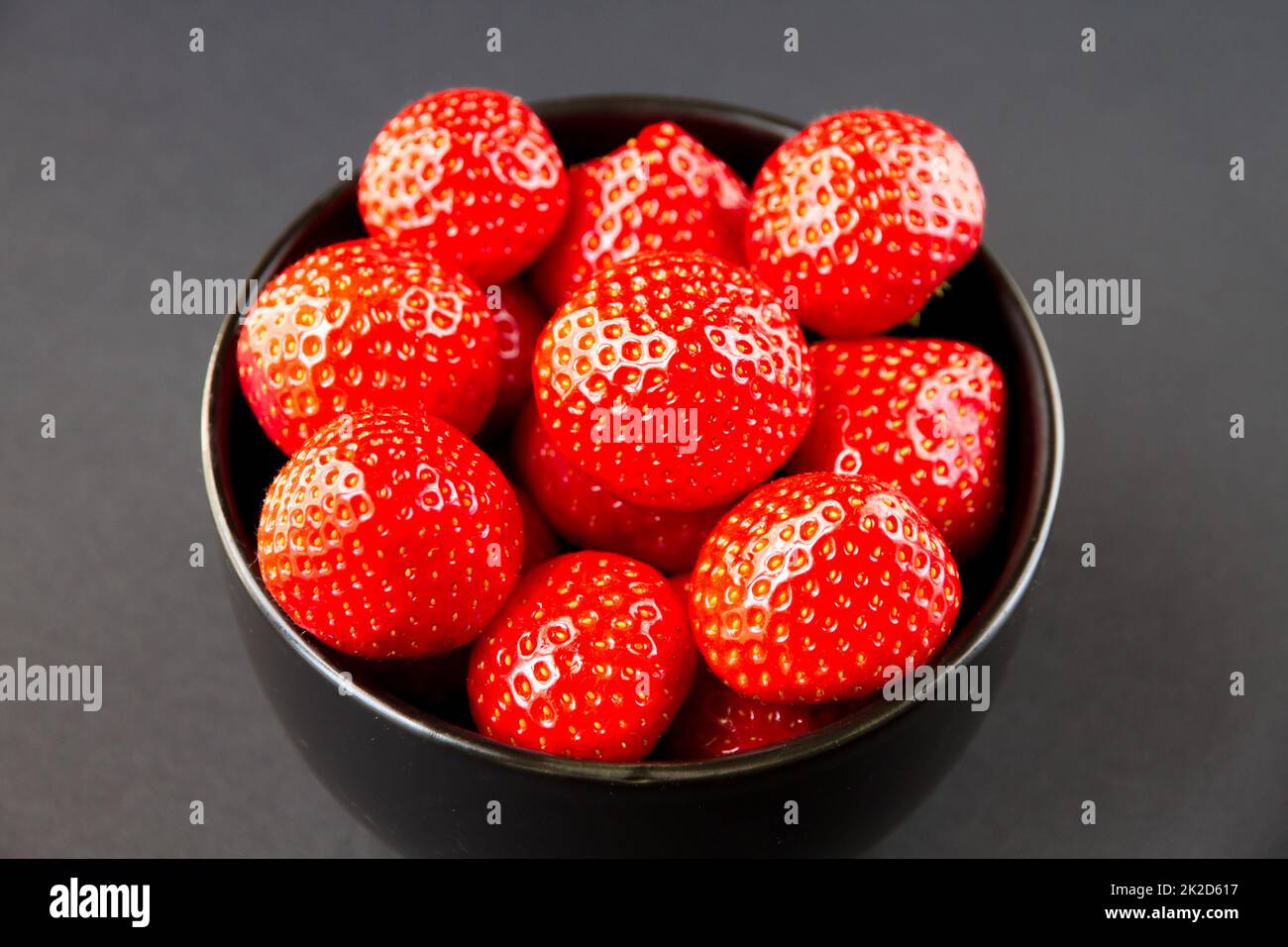 Strawberries in a bowl. Black background Stock Photo - Alamy