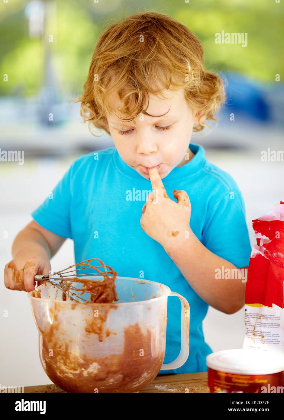 The future of the culinary arts. A little boy covered in dough and