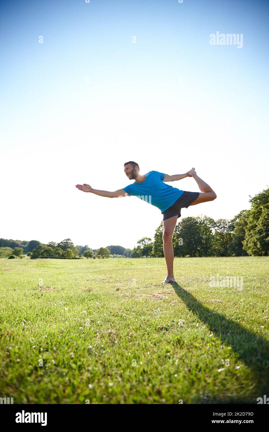 Challenge yourself. Full length shot of a handsome mature man doing yoga outdoors. Stock Photo