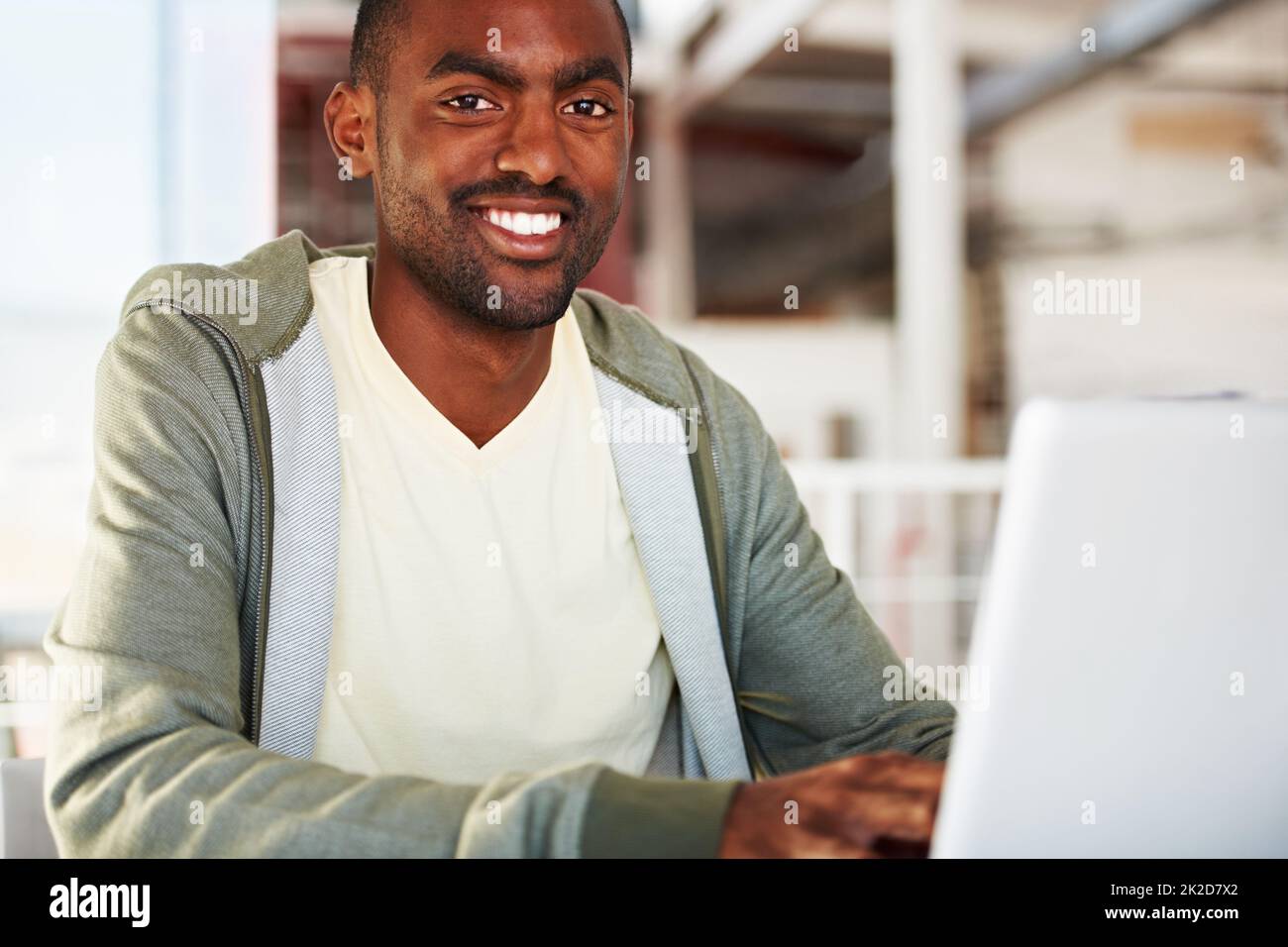 Loving his job. Portrait of a young african man working on his laptop. Stock Photo