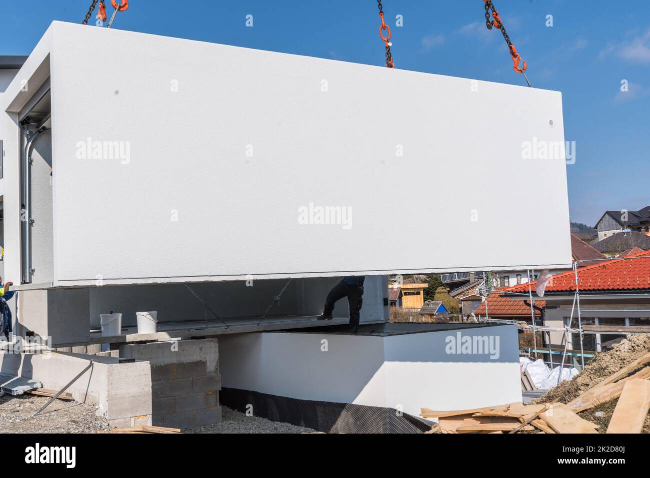 Construction crane sets up prefabricated garage - house building and construction industry Stock Photo