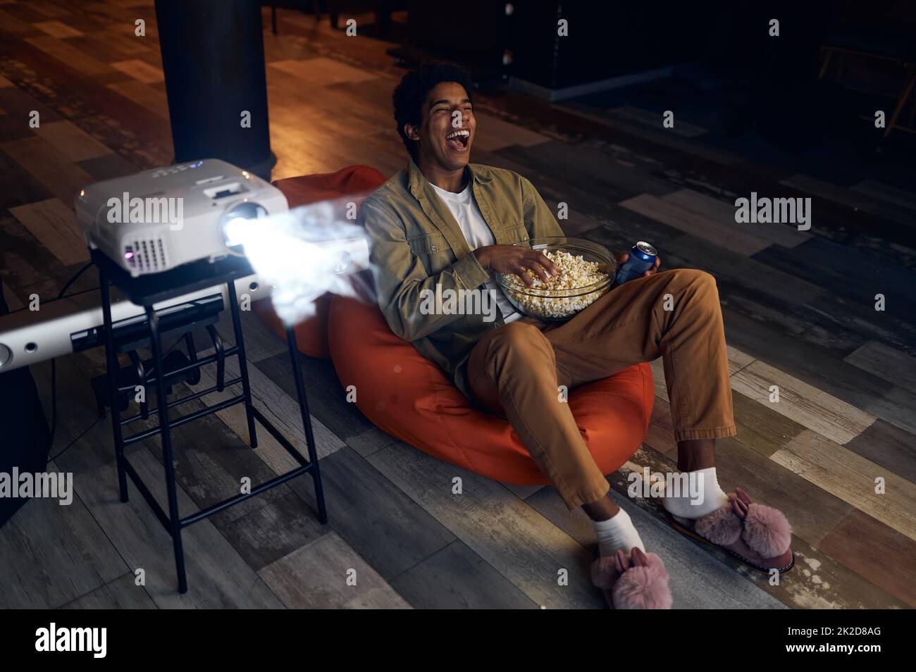 Happy young man laughing during watch film Stock Photo